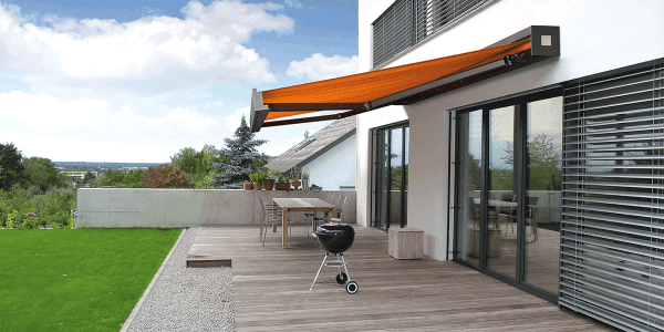 Orangefarbene Markise über einer großzügigen Terrasse